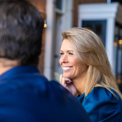 afbeelding van lachende vrouw die naast een man zit waarvan de achterkant van zijn hoofd in beeld is.