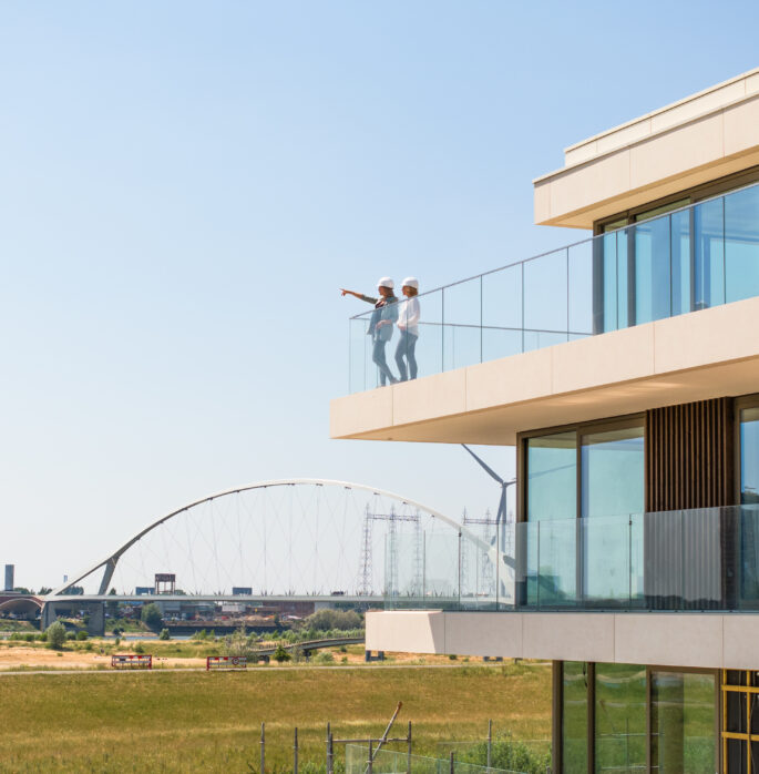 Collega's op balkon nieuwbouwflat