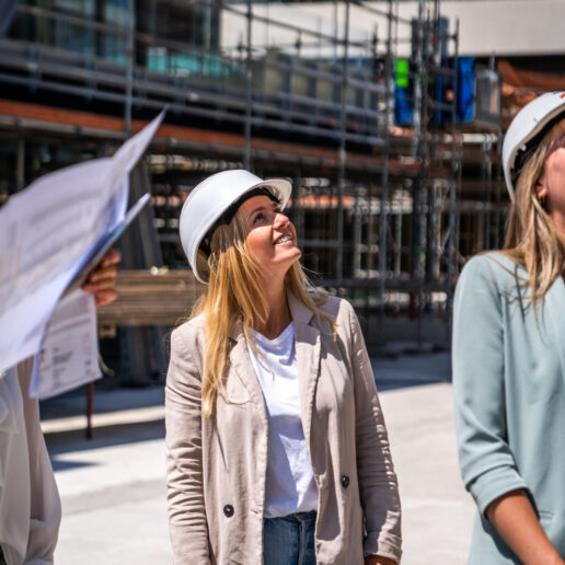 Collega op bouwplaats lachend naar boven kijkend