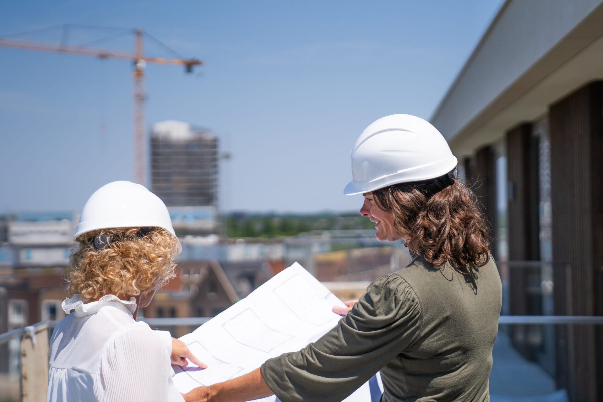 Afbeelding collega's met plattegrond op bouwplaats