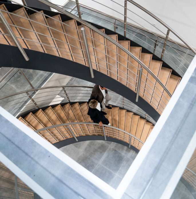 Twee collega's gefotografeerd lopend op trap