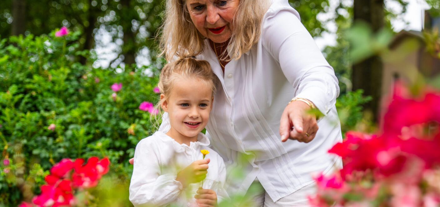 foto van oma en kleinkind bij een veld bloemen