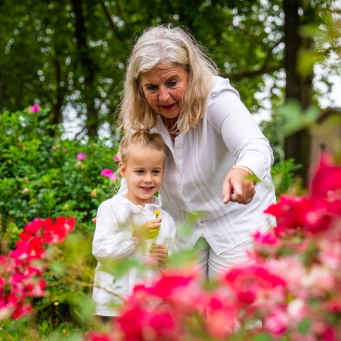 foto van oma en kleinkind bij een veld bloemen