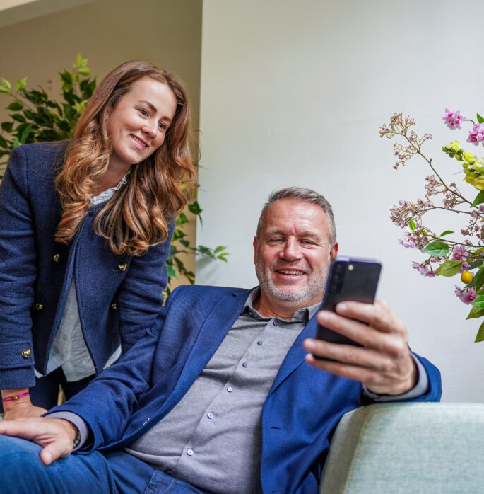 Collega's kijken samen naar telefoon