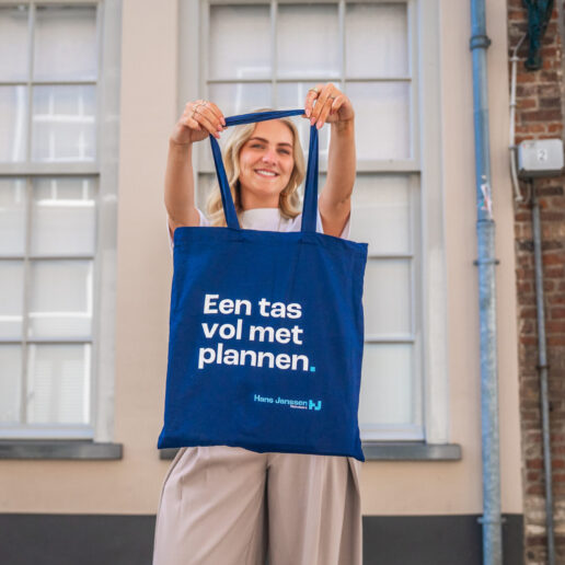 Vrouw houdt blauwe tas omhoog voor een winkelpand